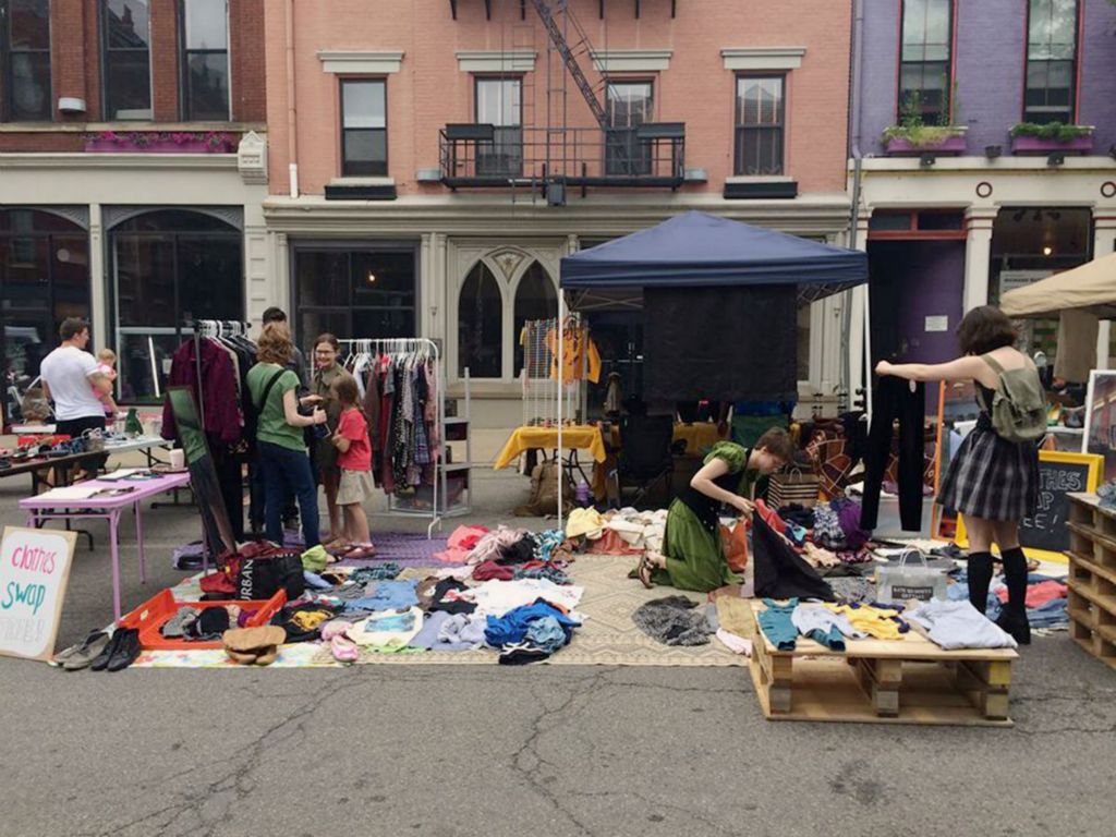 people swapping clothing from piles outside