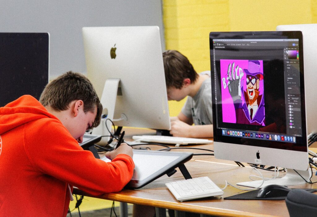 two students working on digital art in a computer lab.